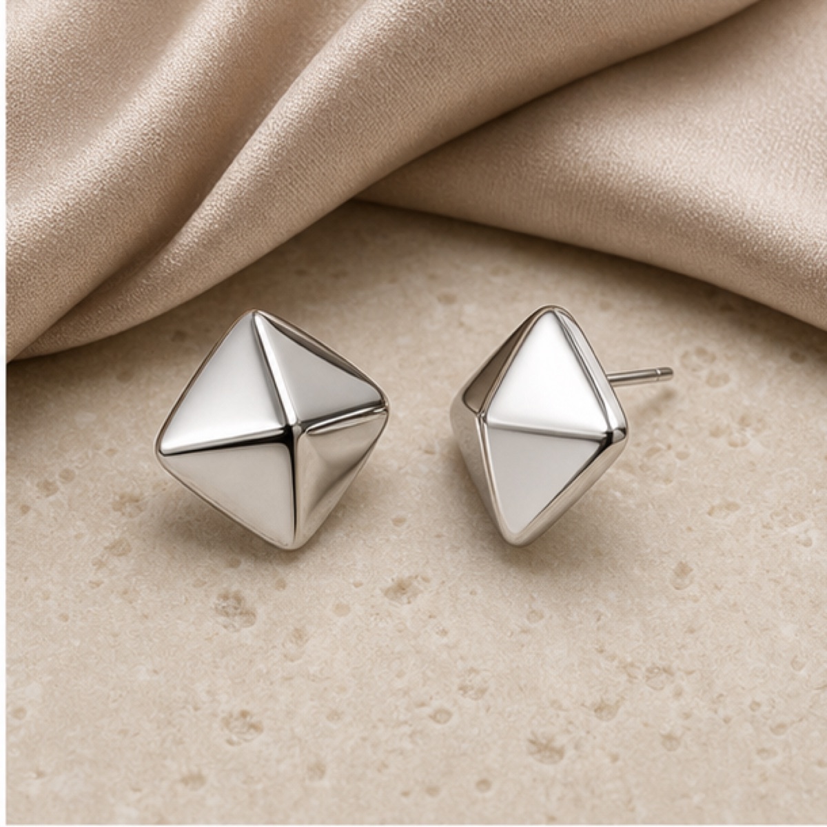 Sculpted Drop Earrings styled on warm stone