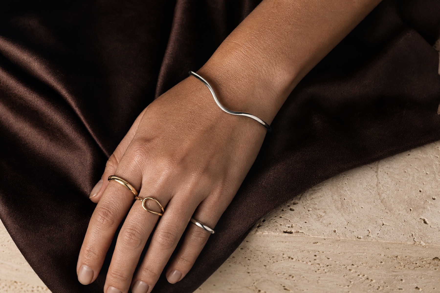 Sculptural rings and bracelet styled on espresso silk